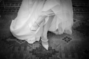 A black and white photo of a bride's feet on a rug captured in New York during her wedding.