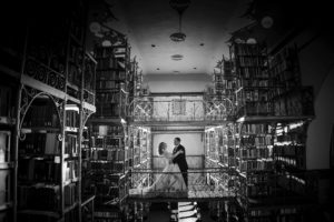 A black and white photo of a bride and groom standing in a library in New York.