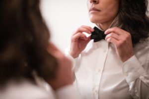 A woman in New York is adjusting her bow tie.