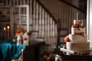 A wedding cake sits on a table in front of a New York staircase.