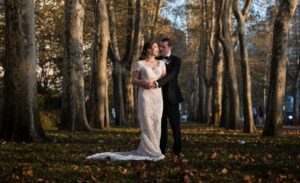 A newlywed couple standing in the middle of a park in New York City on their wedding day.