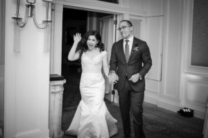 A bridal couple walking out of a doorway in New York after their wedding.