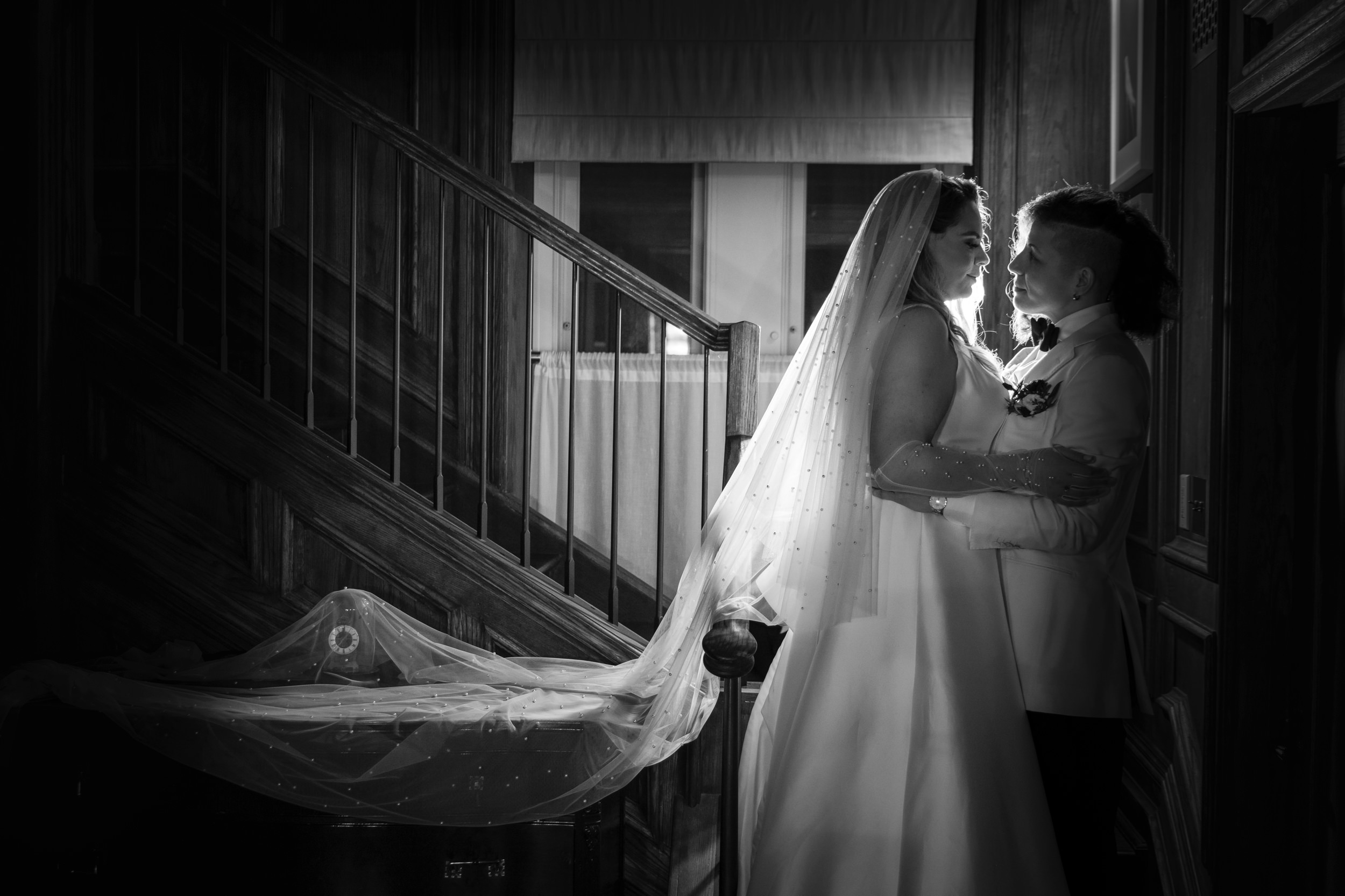 Two brides on the staircase in the penthouse at a Beekman Hotel wedding in NYC