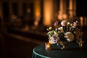 Description: A new york wedding arrangement of flowers on a green table.