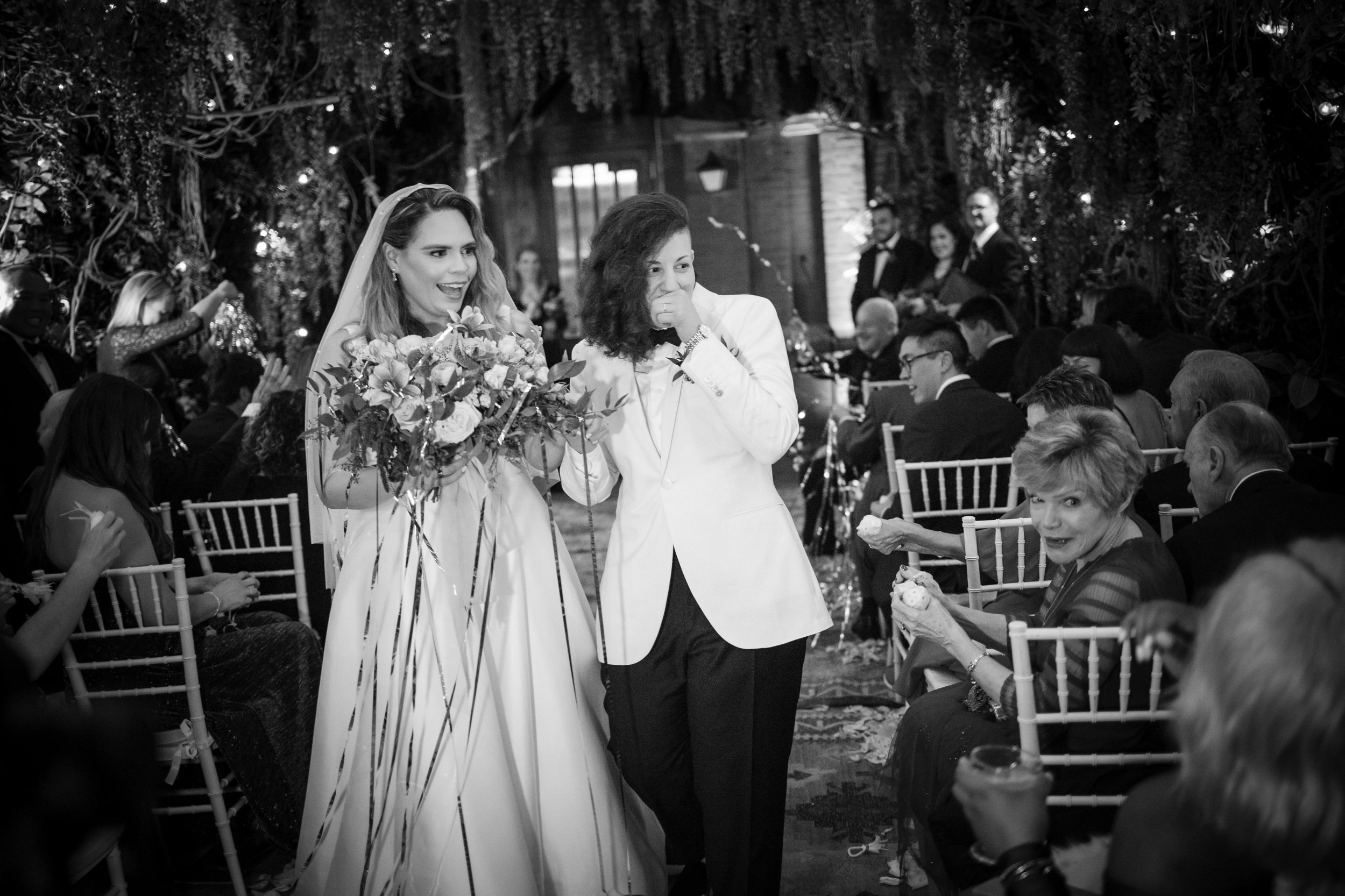 Two brides with streamers during their ceremony at a Beekman Hotel wedding in NYC