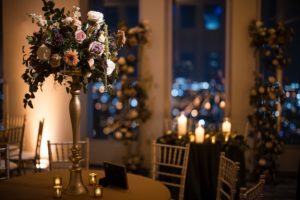 A wedding reception in New York City with candles and flowers, overlooking the stunning cityscape.