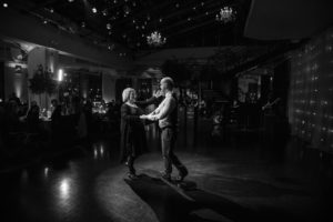 A black and white photo of a couple dancing in a dark room during a wedding ceremony in New York.