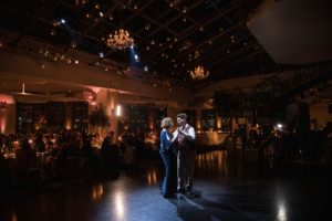 A bride and groom dance in a large room with chandeliers at their wedding in New York.