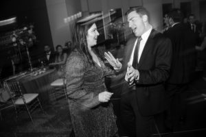 A man and woman, elegantly attired for a wedding in New York, gracefully dancing at the reception.