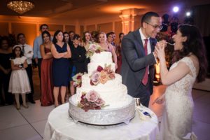 A newlywed couple cutting into a wedding cake in New York City.