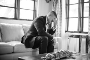 A man in a suit sitting on a couch in New York.