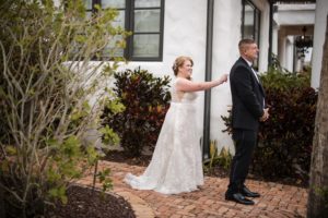 A bride and groom standing next to each other in front of a house in New York.