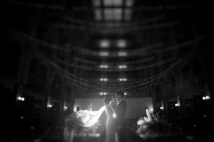 A black and white photo of a bride and groom in the library, captured during their New York wedding.