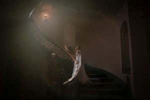 A bride standing on a staircase in a stunning, ornate New York building during her wedding.