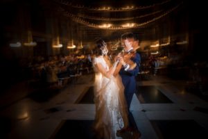 A bride and groom dancing in a dimly lit room during their New York wedding.