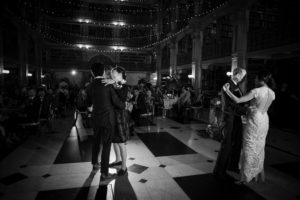 A bride and groom have a romantic dance in the library at night during their New York wedding.