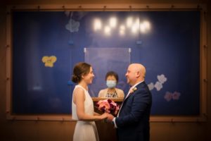 A bride and groom exchange vows in front of a painting at their New York wedding.