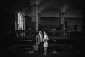 A black and white photo capturing a wedding couple standing in an old building in New York.