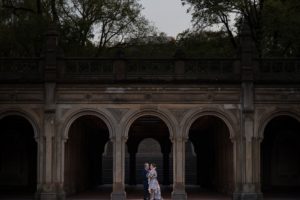 A wedding couple standing in an archway in Central Park, New York.