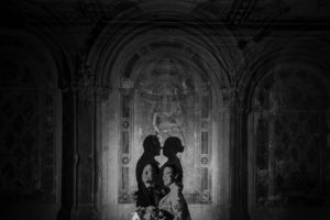 A black and white photo of a wedding couple in an ornate building.