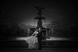 A wedding couple posing in front of a fountain in Central Park, New York.