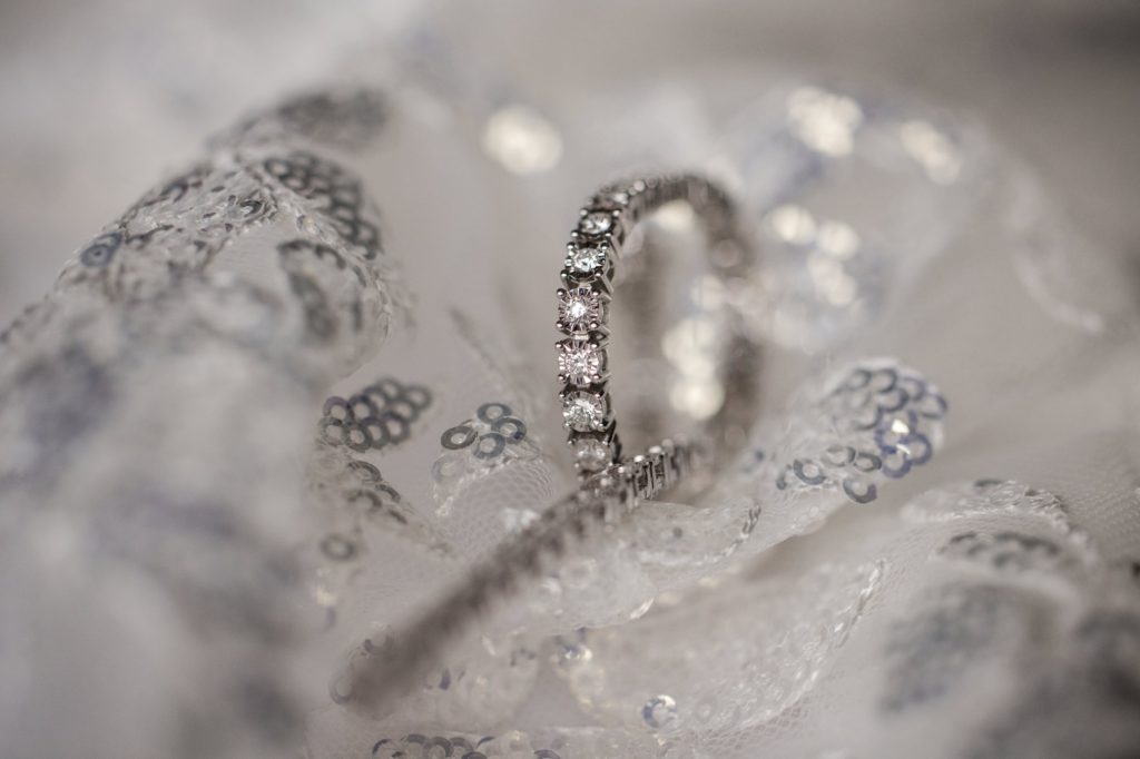A wedding ring from New York sits on a piece of lace.