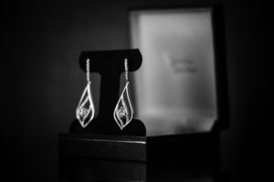 A pair of earrings in a box, photographed in black and white.