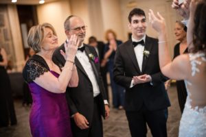 A bride and groom clapping at a wedding reception in New York.