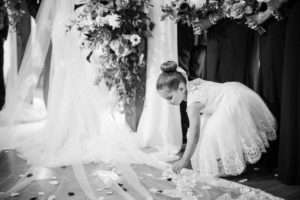A little girl is laying petals on the floor at a wedding in New York.