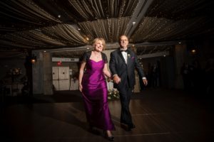 A man and woman in formal attire elegantly gliding across the dance floor at a New York wedding.