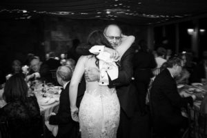 A newlywed couple hugging at their New York wedding reception.