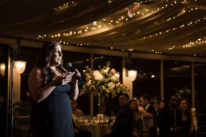 A woman speaking into a microphone at a New York wedding reception.