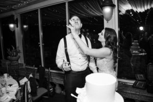 A New York wedding with the bride and groom feeding each other their wedding cake.