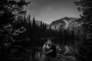 A black and white wedding photo of a couple in front of a lake in New York.
