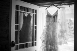 A wedding dress hanging in a doorway, captured in a black and white photo in New York.
