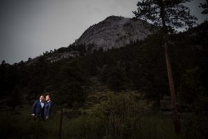 A bride and groom standing in front of a mountain in New York during their wedding.