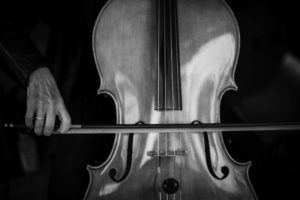 A black and white photo of a person playing a cello at a wedding in New York.