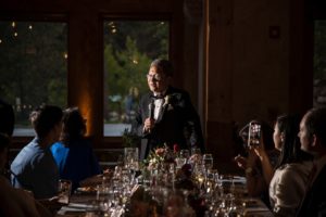A man giving a speech at a wedding in New York.
