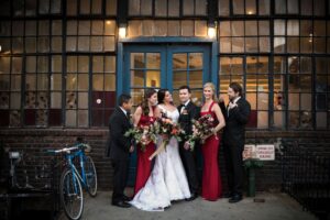 A group of bridesmaids and groomsmen standing outside the Bowery Hotel on their wedding day.