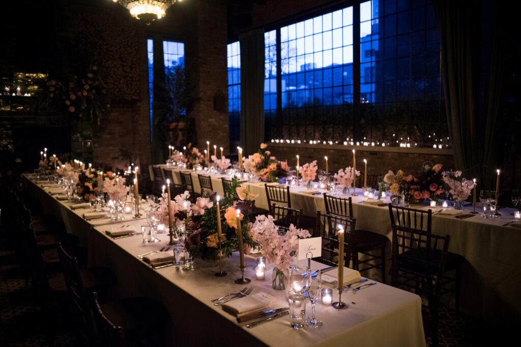 A romantic wedding table adorned with candles and flowers at the Bowery Hotel.