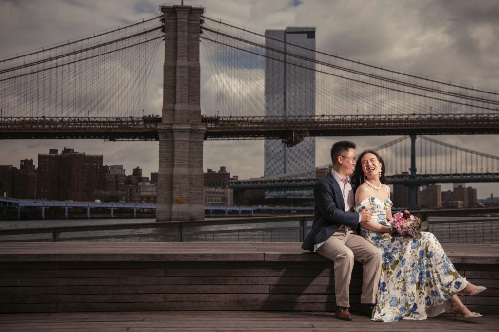 Newlyweds in New York pose for a photo in front of the Brooklyn Bridge on their wedding day.