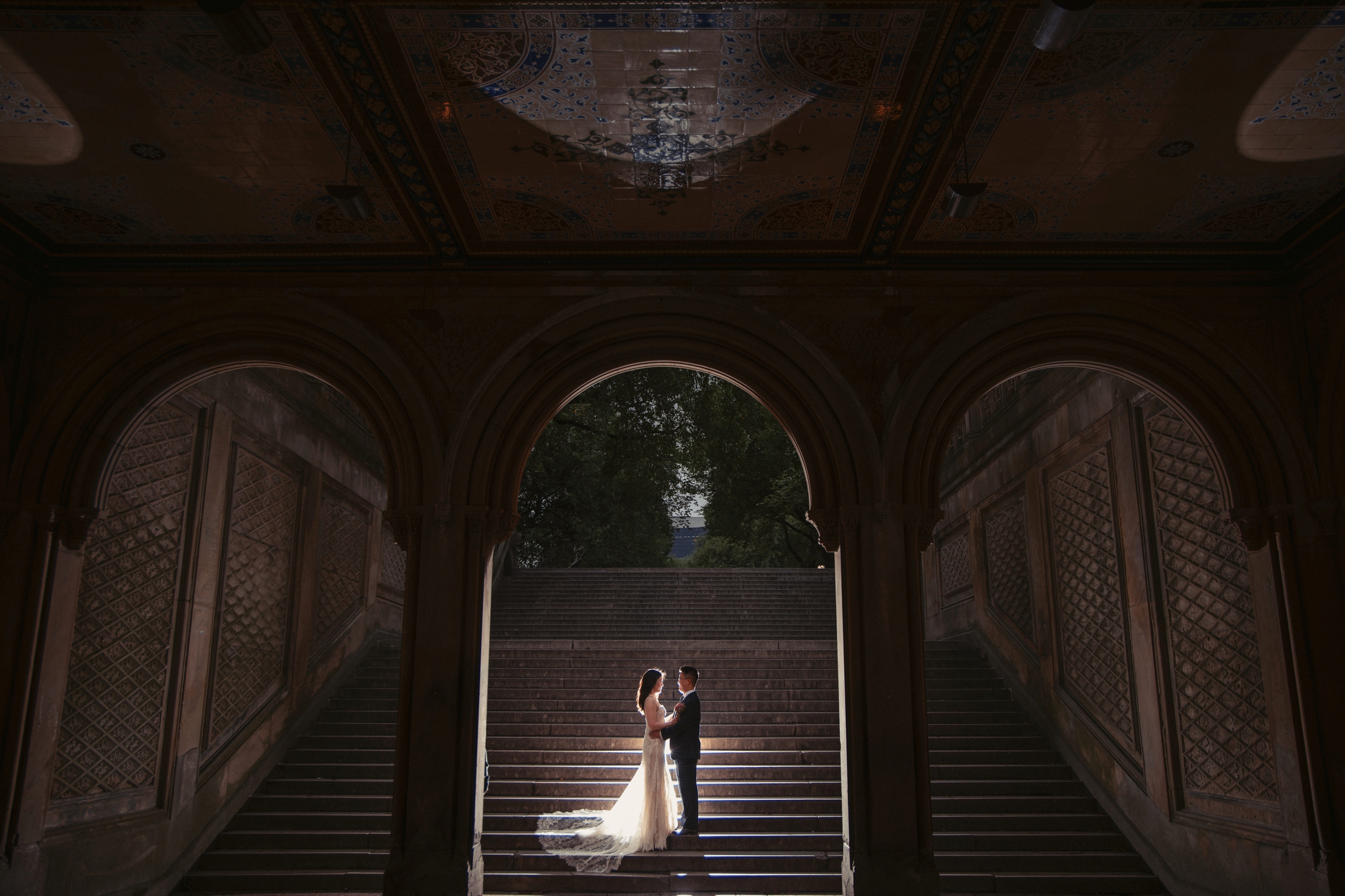 wedding couple on the steps of bethesda terrace in central park on their wedding day