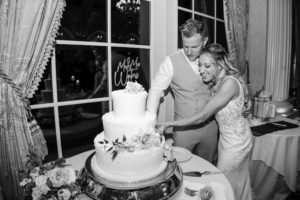 Ashford Estate wedding black and white photo of a bride and groom cutting their wedding cake by the windows
