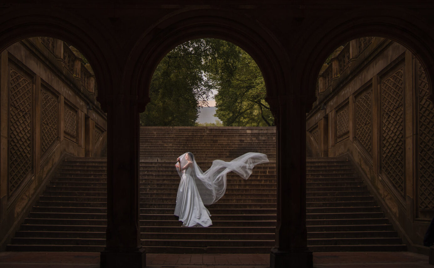 bride with a veil on the steps of bethesda terrace in central park