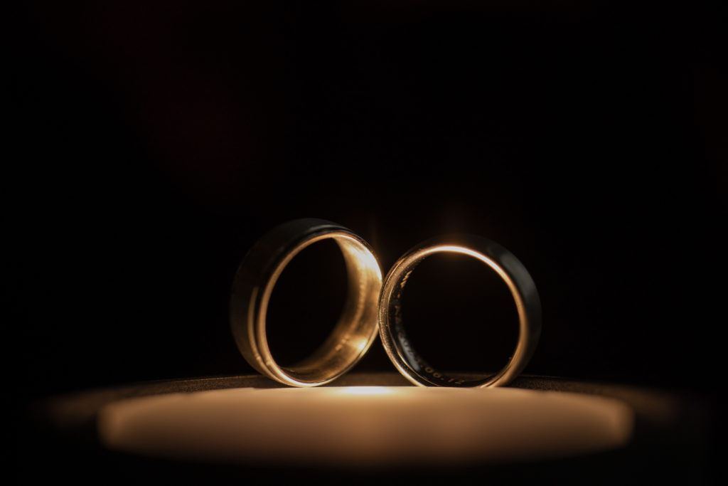 Two wedding rings on top of a candle at a romantic New York wedding ceremony.
