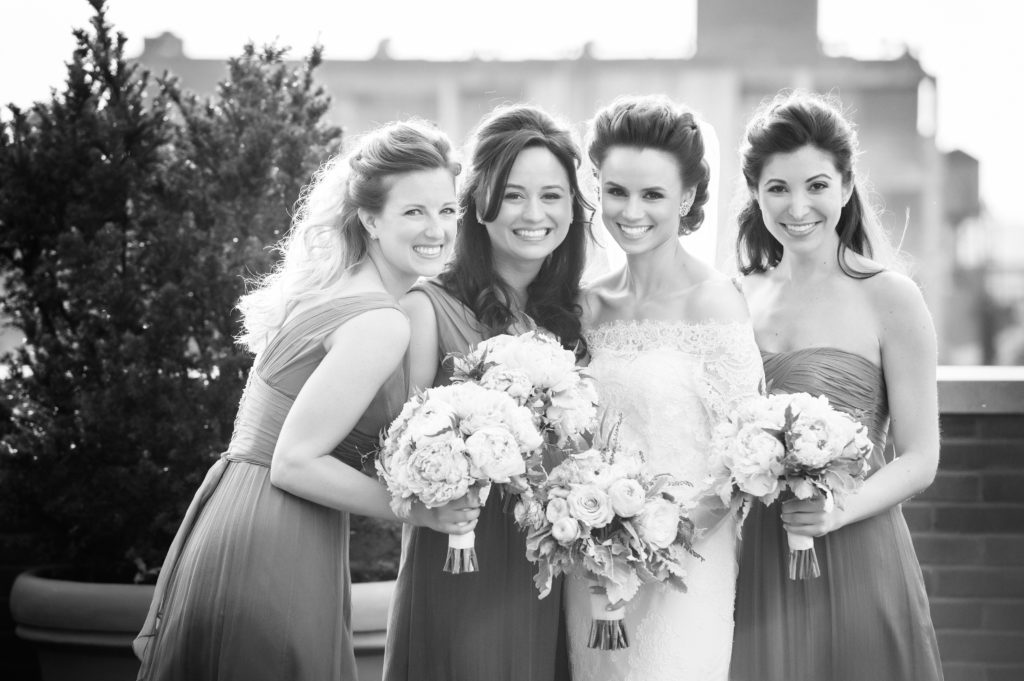 A bride and her bridesmaids on the balcony of a Bowery Hotel suite.