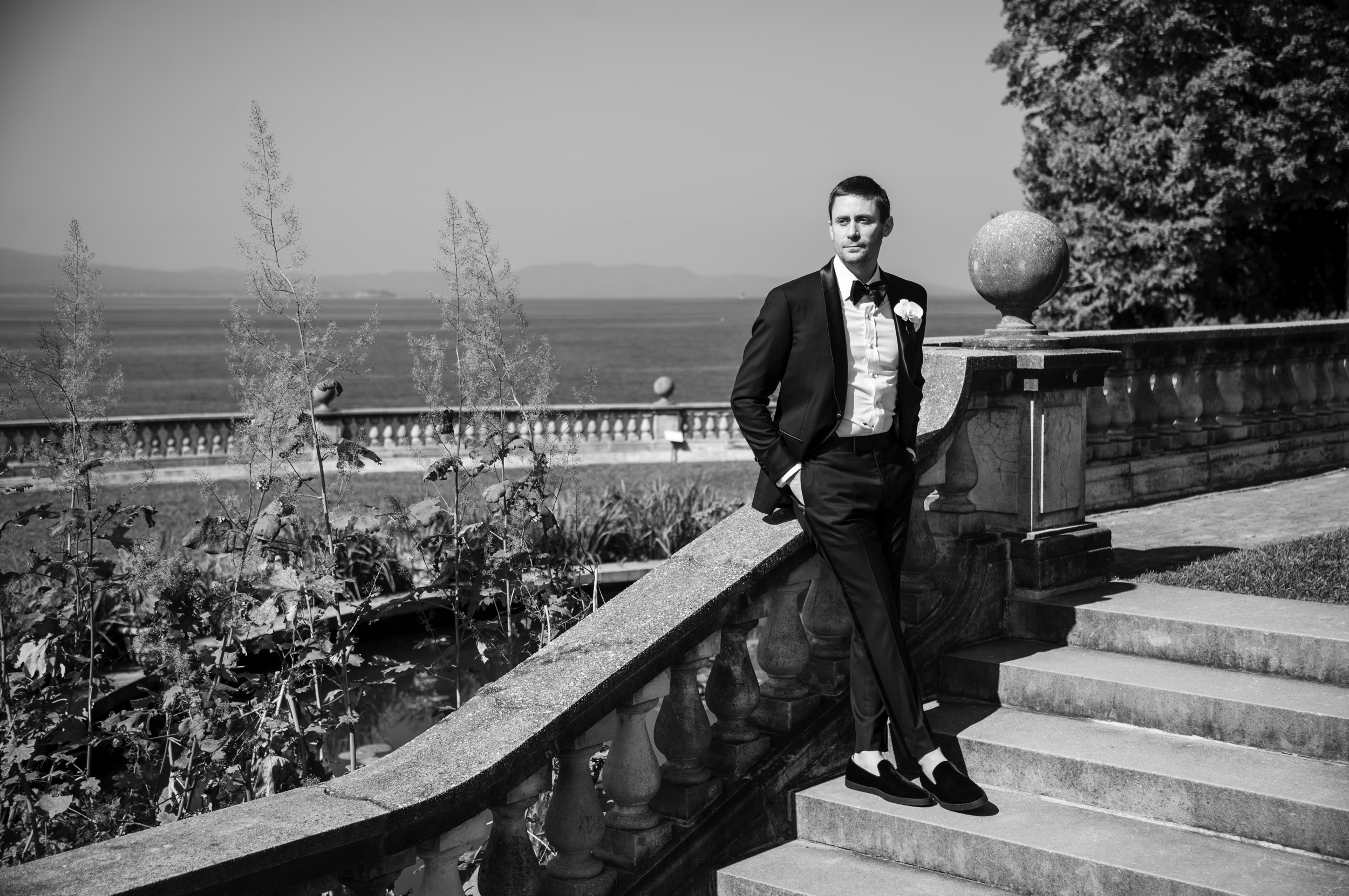 groom on steps by lake shelburne inn wedding