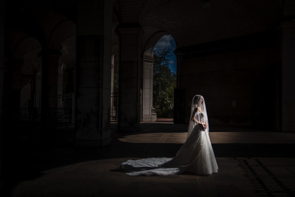 A bride in a wedding dress standing in the entrance to a luxury hotel.