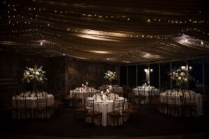 wedding reception table decor dark room with white flowers and lighting