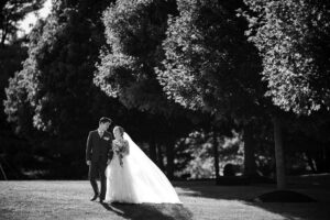bride and groom walking across a field to ceremony